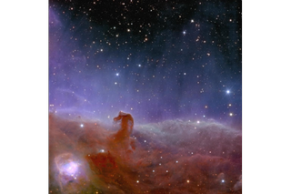 At the bottom of the screen, a lot of hazy-looking reddish gas coalesces to form a small hook shape on the left.  Above, there is a glow of purple light that gradually fades at the top of the image, showing a dark region of star-flecked space.